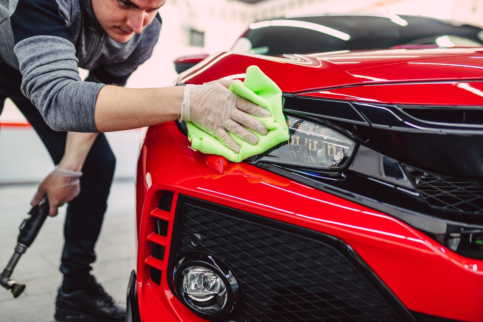A man cleaning car with cloth, car detailing (or valeting) concept. Selective focus. A man cleaning car with cloth, car detailing (or valeting) concept. Selective focus.